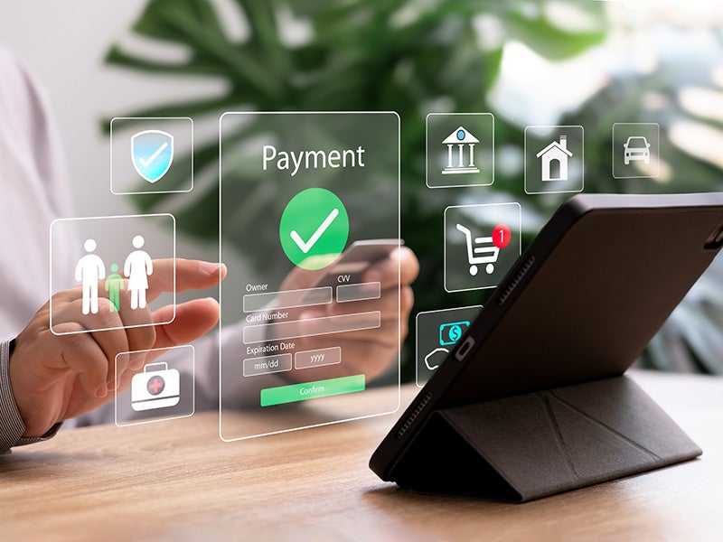 A person using a smartphone to interact with a virtual payment form and various glowing icons on a digital interface.